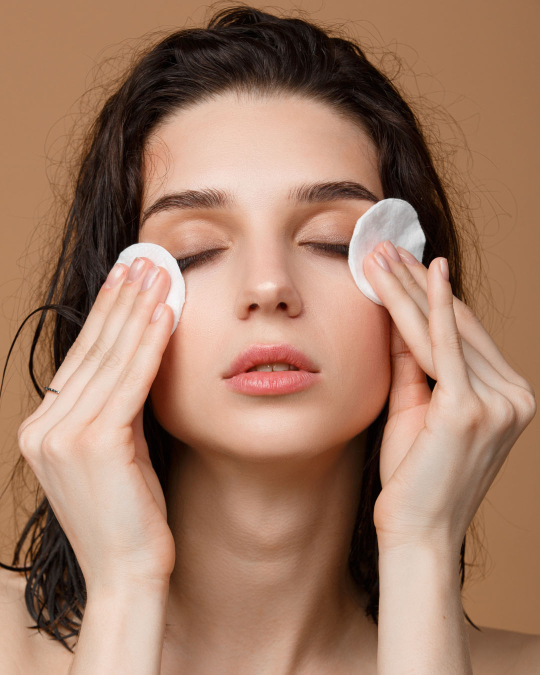 ragazza che rimuove il trucco dagli occhi con due dischetti di cotone asciutti - dermaclub